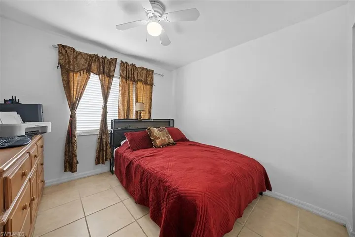 Bedroom with light tile patterned floors and a ceiling fan