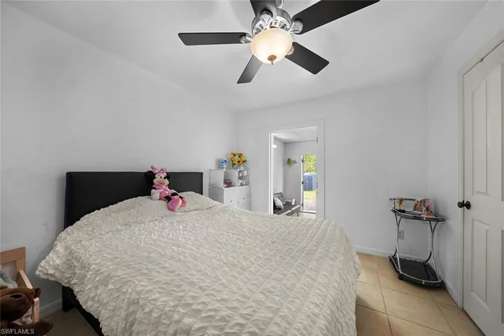 Bedroom with ceiling fan and light tile patterned floors