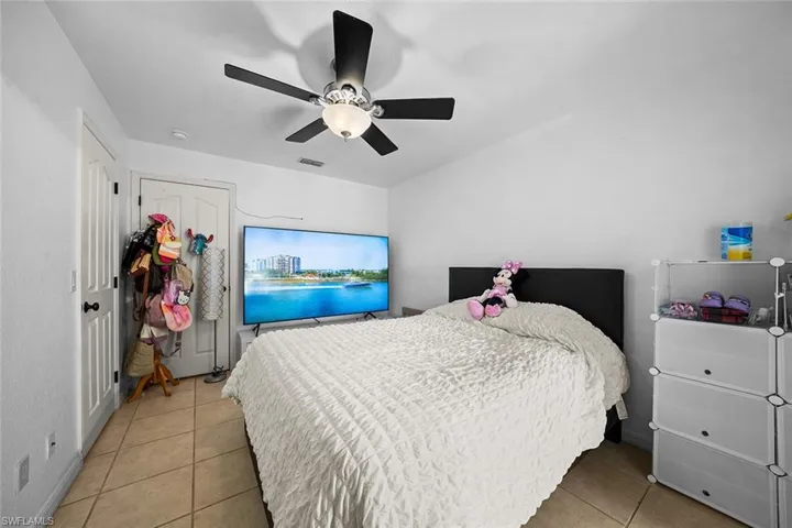 Bedroom featuring light tile patterned floors and ceiling fan