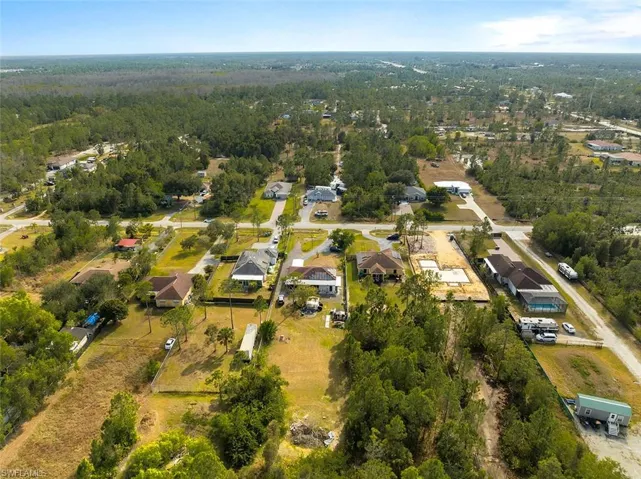 Aerial view of property's location with a forest and nearby suburban area