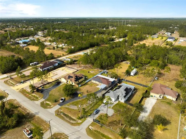 Aerial view of property and surrounding area with nearby suburban area