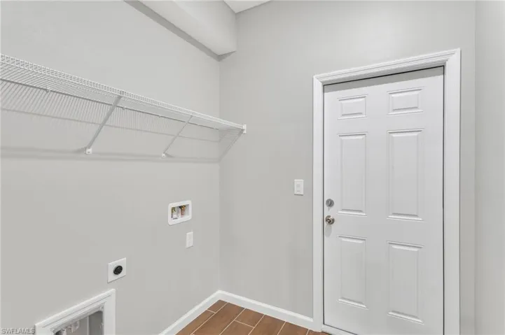 Washroom with laundry area, washer hookup, hookup for an electric dryer, dark wood-style flooring, and baseboards