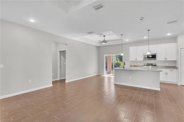 Kitchen with a tray ceiling, recessed lighting, visible vents, and stainless steel appliances