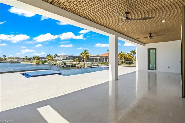 Relaxing pool / spa featuring a patio, a residential view, and a water view