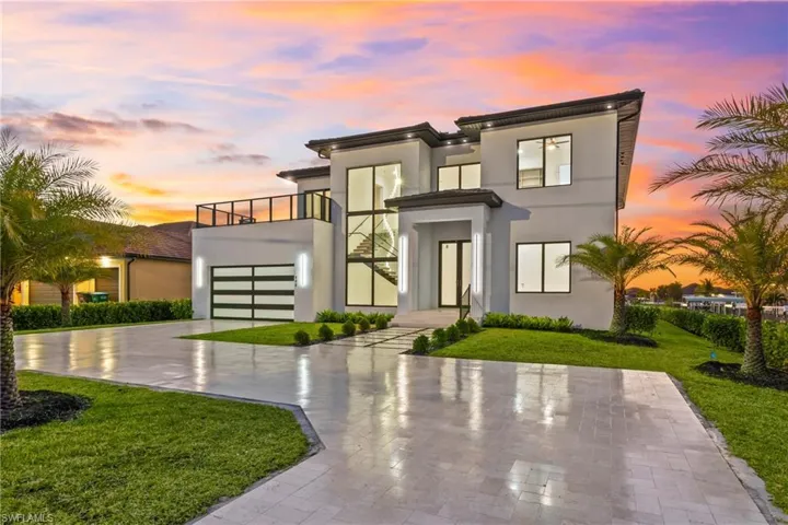 Contemporary home featuring a lawn, stucco siding, driveway, and a garage