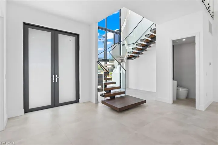 Entrance foyer featuring french doors and concrete flooring