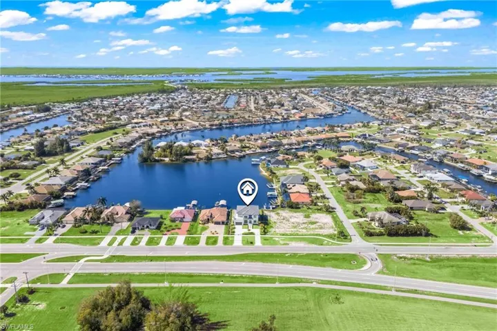 Aerial perspective of suburban area featuring a nearby body of water
