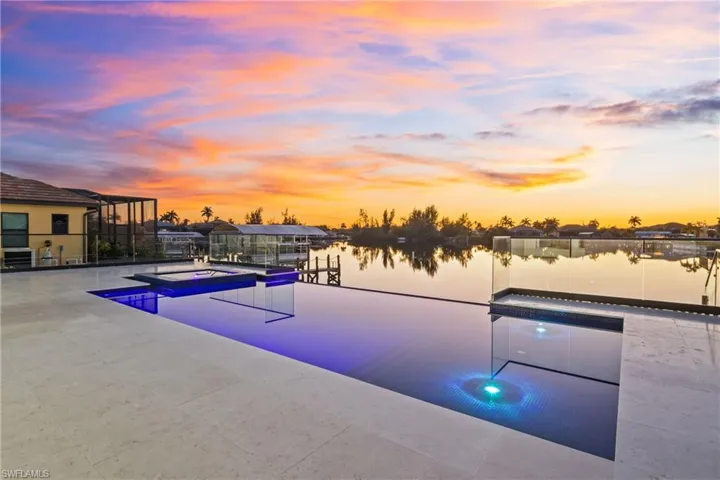 Pool at dusk featuring a pool with connected hot tub