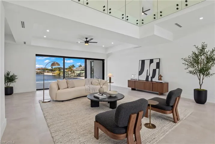 Living area featuring ceiling fan, recessed lighting, and a high tray ceiling