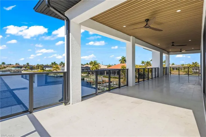 View of patio with a ceiling fan, a residential view, and a water view