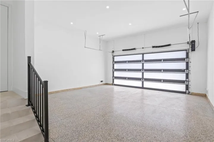 Garage featuring baseboards and recessed lighting