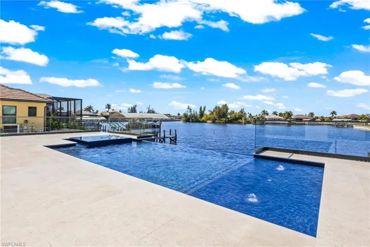 Outdoor pool with a dock and a water view