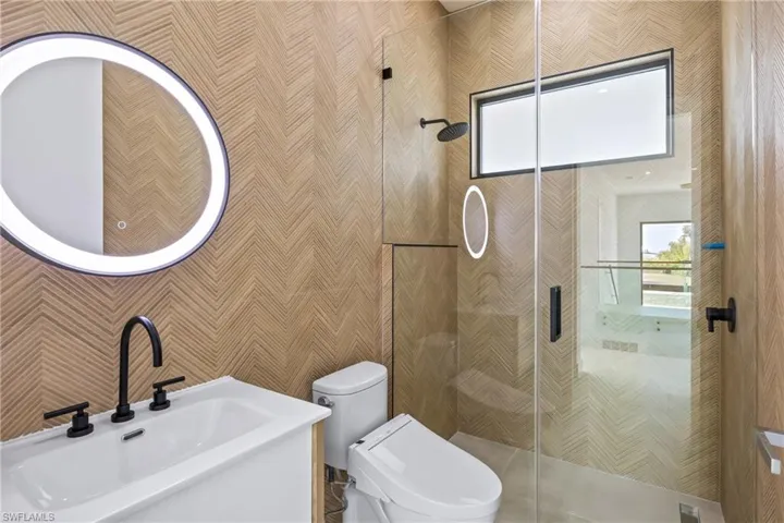 Full bath with a stall shower and wallpapered walls
