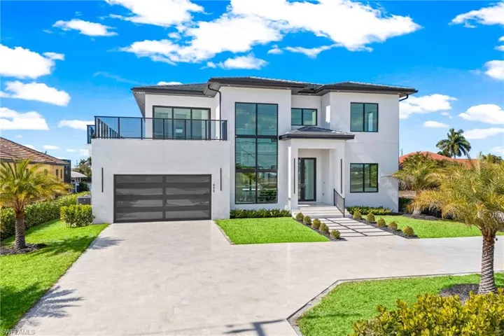 Contemporary home featuring driveway, a front lawn, stucco siding, and an attached garage