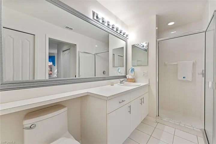 Walk-in shower, large vanity, & linen closet in bathroom.
