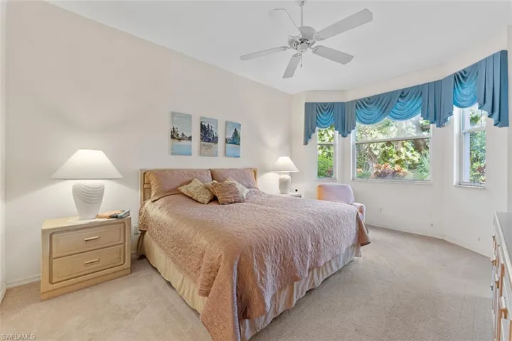 Primary bedroom overlooking lush landscaping.