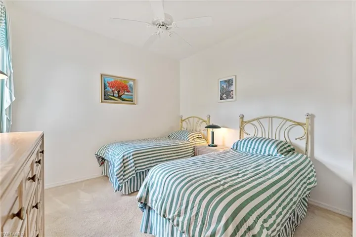 Guest bedroom with generous-sized closet, & a large window for light.