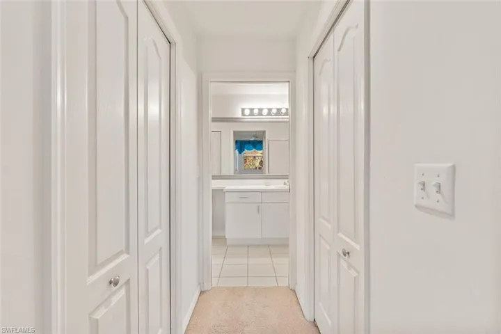 Two large walk-in closets in hallway leading to primary bathroom.