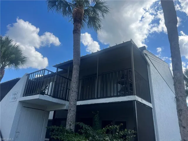 View of side of home with a balcony, stucco siding, and a sunroom
