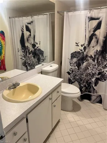 Full bath with vanity, light tile patterned flooring, and a shower with shower curtain