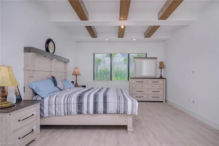 Bedroom featuring beamed ceiling, wood finished floors, and recessed lighting