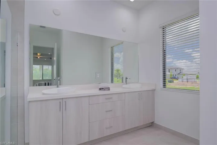Full bath featuring double vanity and tile patterned flooring