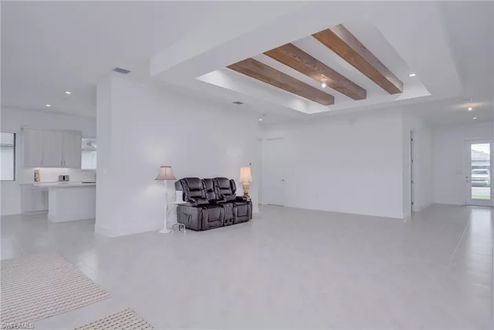 Sitting room with recessed lighting, beamed ceiling, and light tile patterned floors