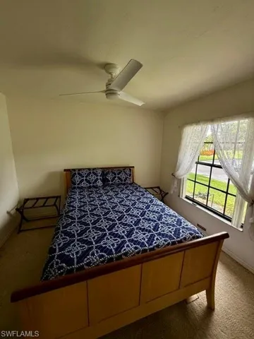 Bedroom featuring a multi-pane window, ceiling fan, and light-toned wall paint