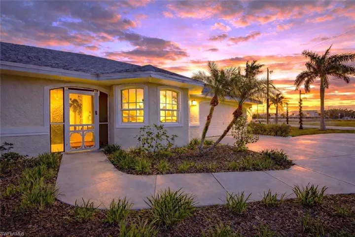 View of front of house featuring stucco siding, driveway, a garage, and roof with shingles