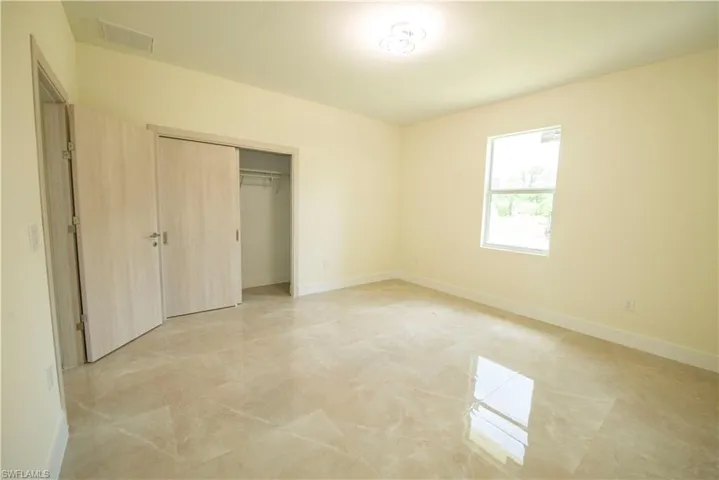 Unfurnished bedroom with a closet and baseboards