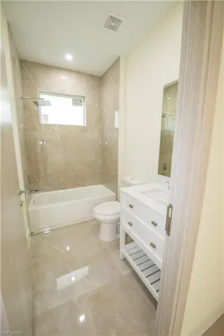 Bathroom featuring vanity, shower / bathtub combination, and recessed lighting