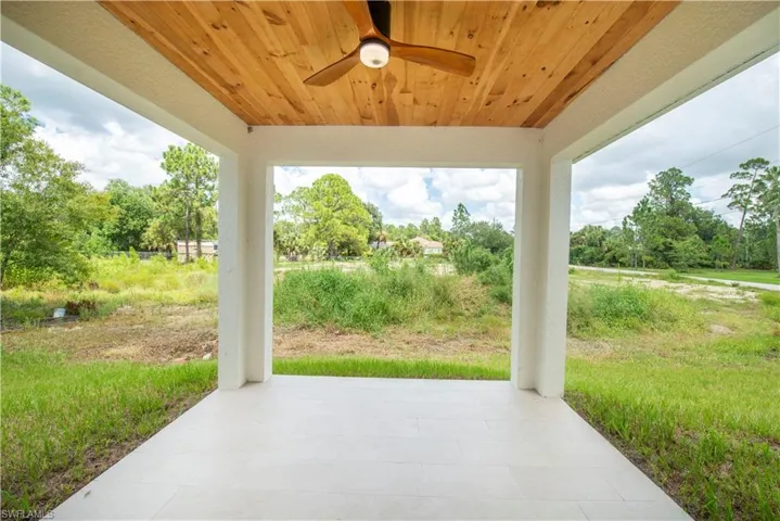 View of patio featuring a ceiling fan and view of wooded area