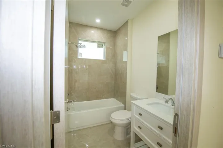 Full bathroom with vanity, shower / tub combination, and recessed lighting