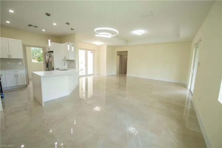 Kitchen with white cabinetry, open floor plan, stainless steel fridge with ice dispenser, and french doors