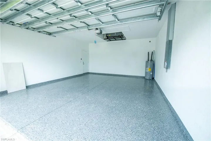 Garage featuring water heater and electric panel