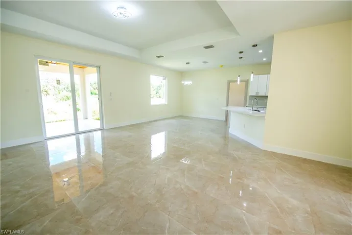 Unfurnished living room featuring light marble finish flooring and recessed lighting