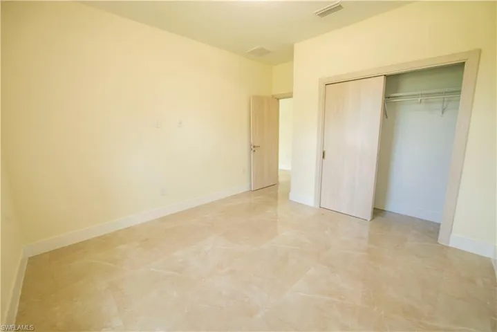 Unfurnished bedroom with baseboards and a closet