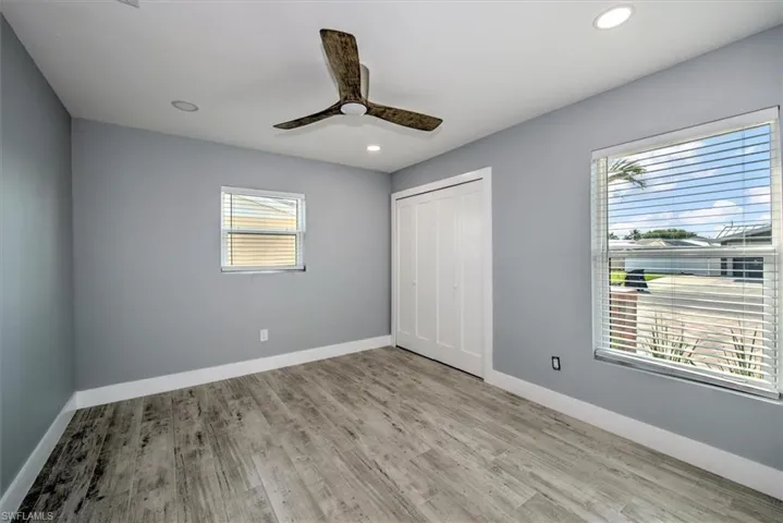 Unfurnished bedroom featuring light wood-type flooring, ceiling fan, and a closet