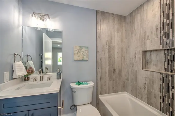 Full bathroom with toilet, shower / washtub combination, and vanity