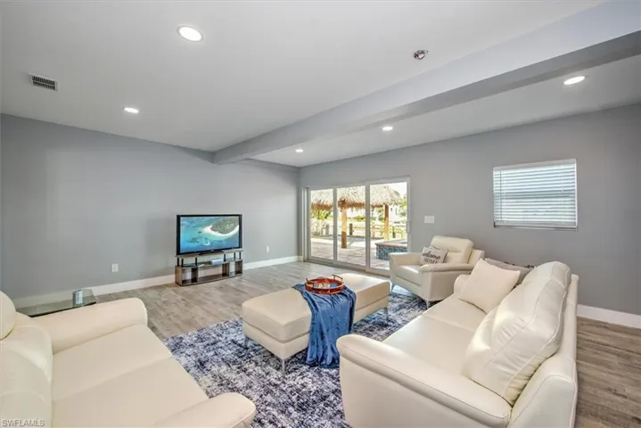 Living room with light wood-type flooring and beam ceiling