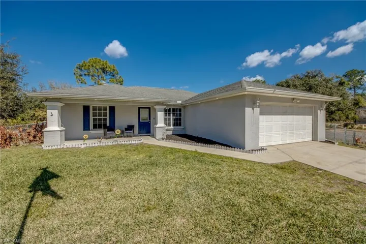 Single story home featuring a garage, driveway, stucco siding, and a shingled roof