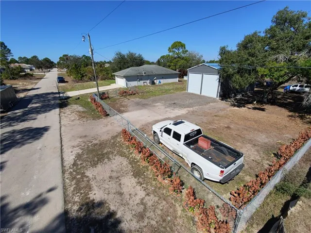 View of yard featuring a detached garage and an outdoor structure