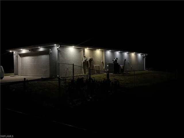 View of front of home featuring a fenced front yard, an attached garage, and driveway