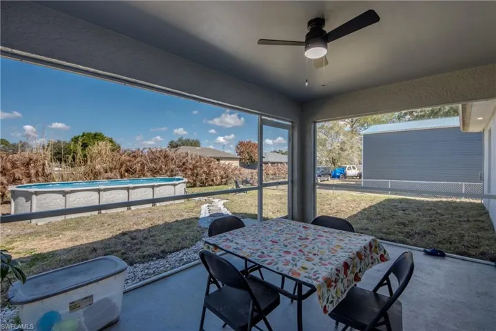 View of patio / terrace featuring outdoor dining space, a ceiling fan, and a sunroom