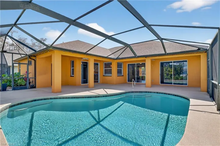 Outdoor pool featuring a sunroom, a patio area, and a lanai