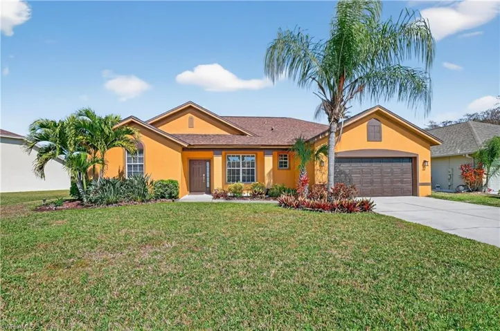 Ranch-style house featuring stucco siding, a front lawn, driveway, and an attached garage