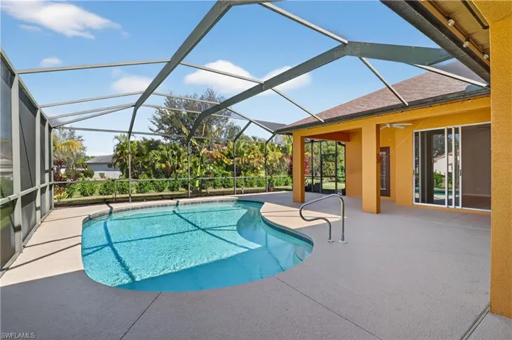 Swimming pool featuring a sunroom, a lanai, and a patio area