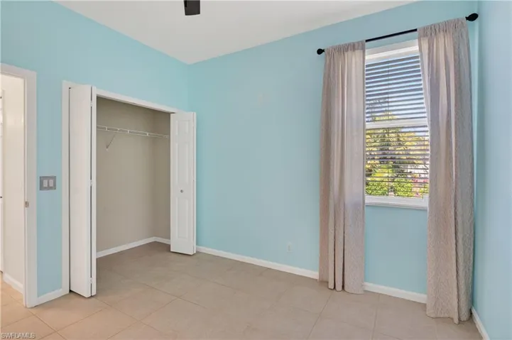 Unfurnished bedroom with a closet, ceiling fan, and light tile patterned floors