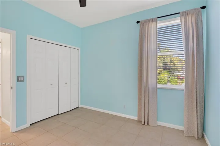 Guest suite bedroom featuring a closet, a ceiling fan, and light tile patterned floors