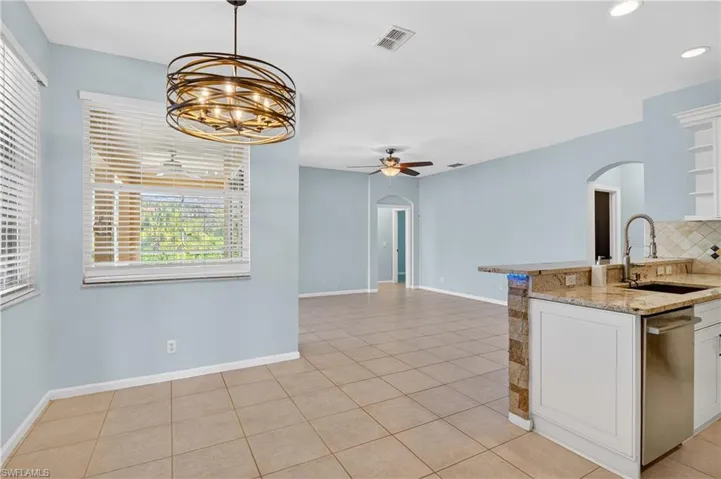 Spare room featuring a ceiling fan, a sunroom, and light tile patterned floors